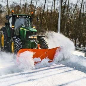 Zielony ciągnik rolniczy John Deere  odśnież ulicę za pomocą pługa do odśnieżania Alps 331 firmy Samasz www.korbanek.pl