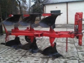 Używany Pług obracalny niemiecki BVL na utwardzonym placu w tle biały budynek