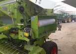 Prasa Claas Variant 260  z 2005 w hali w tle traktor z przyczepą
