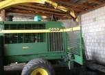 Fotografia boku i otwartej komory z tyłu sieczkarni John Deere 5650.