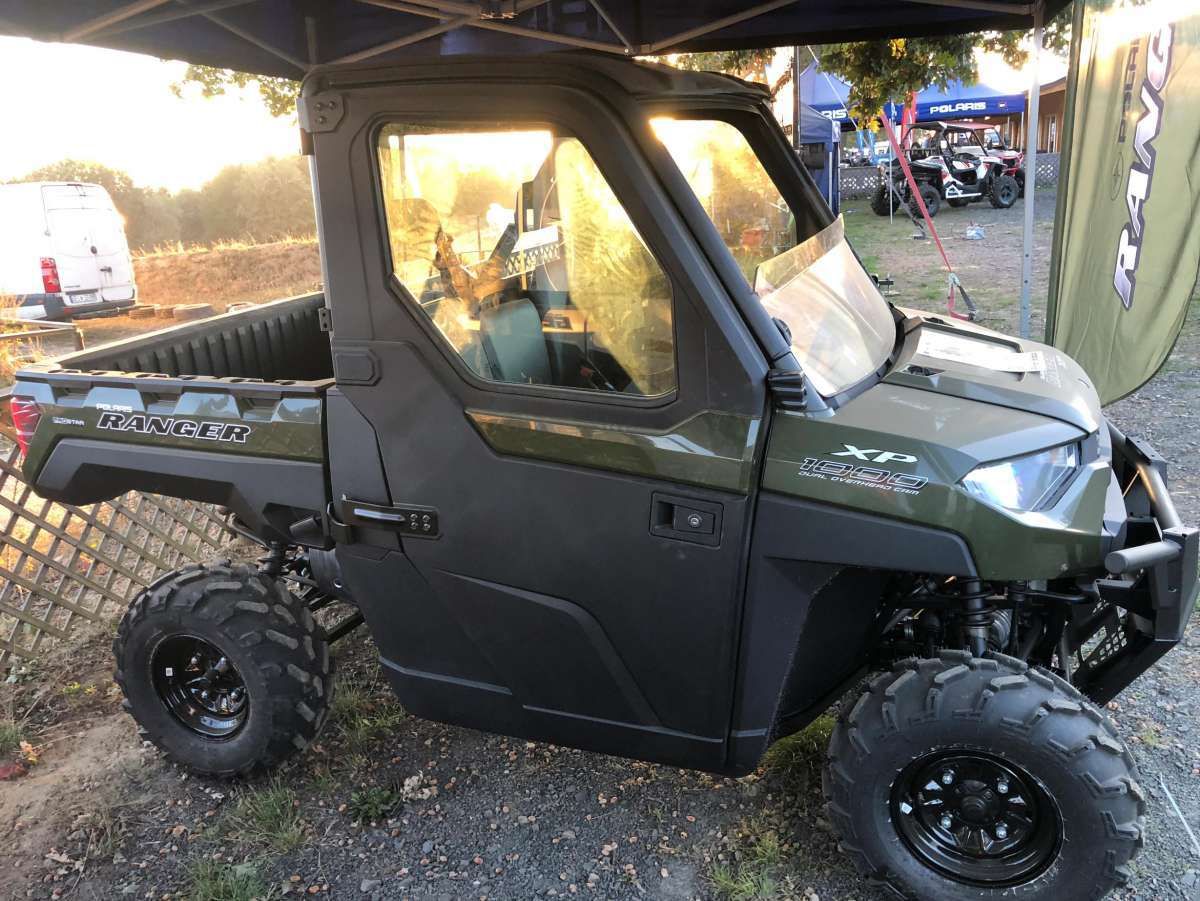 Polaris Ranger 1000 EPS na wystawie Ranger Polaris 1000 Xp ADC kontrola zjazdu wersja dla trzech osób siatki boczne ochronne paka załadunkowa uchylna kolor zielony przedni zderzak metalowy felgi stalowe zagłówki foteli pasy bezpieczeństwa kierownica samochodowa napęd 2x4 4x4 Turf rozpiecie tylnej osi